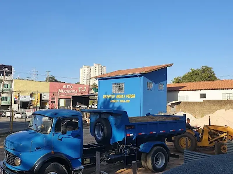 Caminhão azul de entrega em frente ao depósito