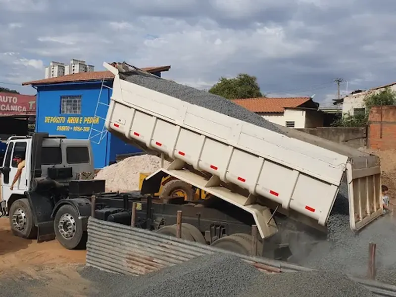Caminhão da Donato descarregando pedra no pátio do depósito