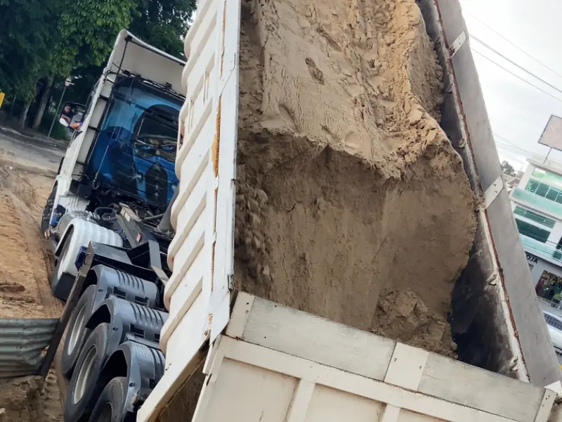 Carreta basculante descarregando areia