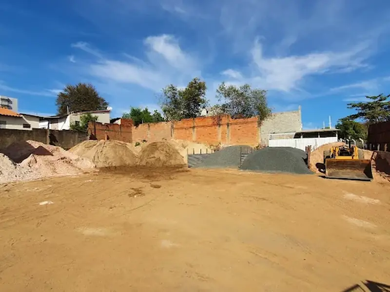 Pátio com pilhas de areia e pedra em Americana